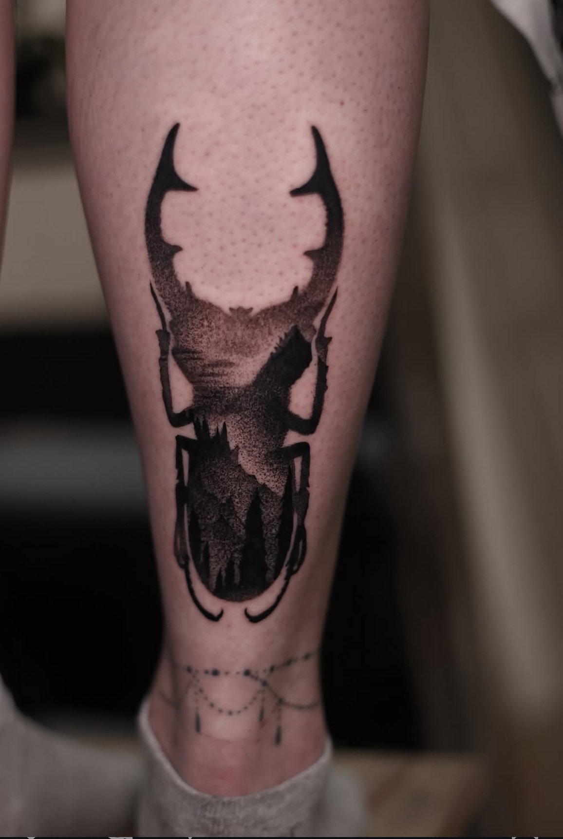 Arsen’s stag beetle tattoo with a forest inside its body